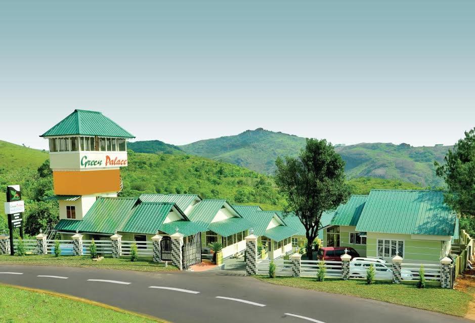 a building with green roofs next to a road at Green Palace Resort in Vagamon