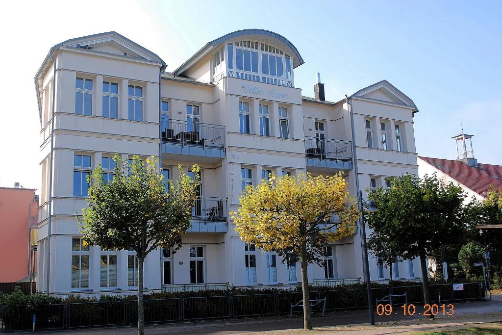 a large white building with trees in front of it at Anna-App-10 in Ahlbeck