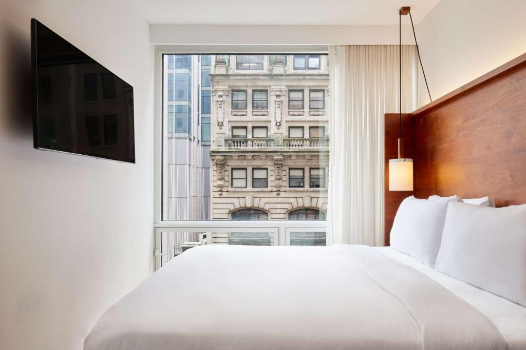 a bedroom with a large white bed and a window at Arlo NoMad in New York