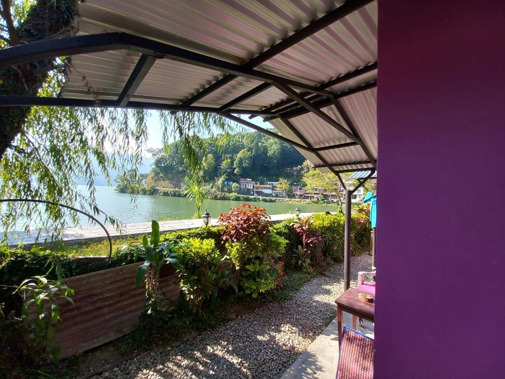 a pergola with a view of a body of water at The Freedom Huts in Pokhara