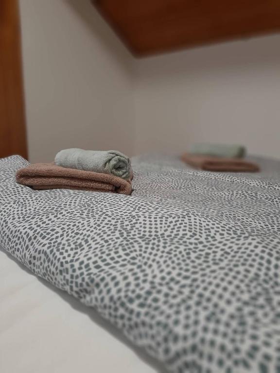 łóżko z kocem i ręcznikiem w obiekcie Portum vendégház w Siófoku