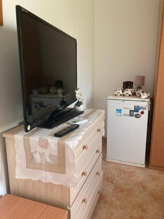 a television on top of a dresser with a refrigerator at Rahel’s Home in Beer Sheva