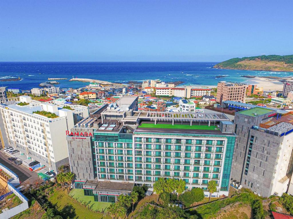 an aerial view of a city with the ocean at Ramada by Wyndham Jeju Hamdeok in Jeju