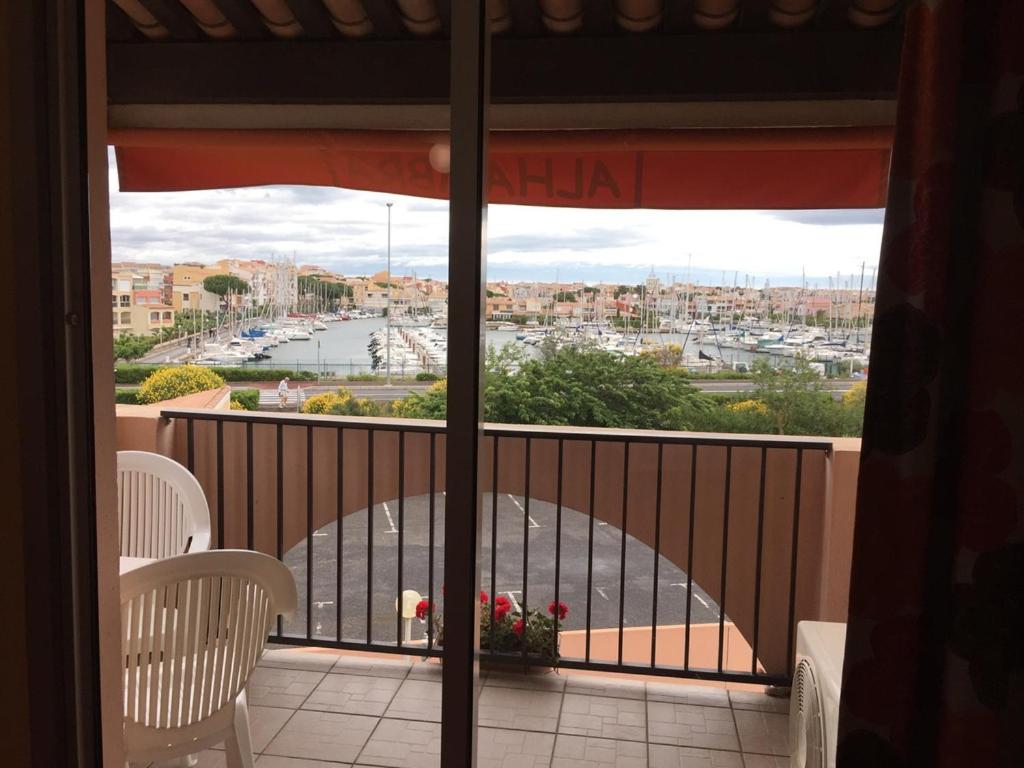 a balcony with chairs and a view of a harbor at Hotel Alhambra in Cap d&#39;Agde