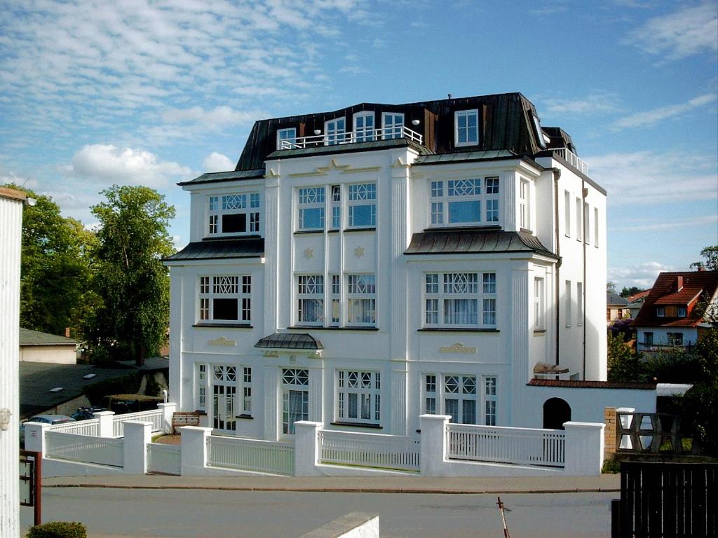 ein weißes Haus mit einem schwarzen Dach in der Unterkunft Hamburg App. 01 in Ahlbeck