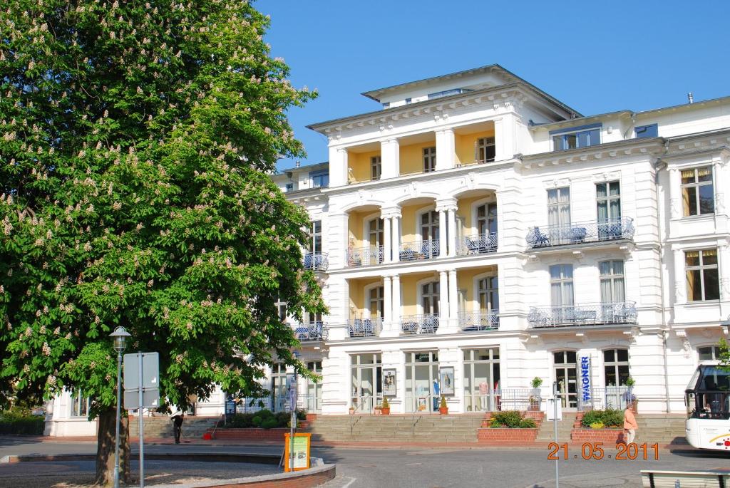 a white building with a tree in front of it at Seeschloss-App-05 in Heringsdorf