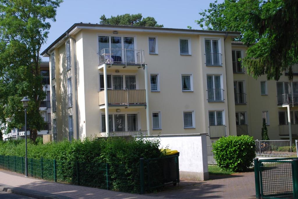 Großes weißes Gebäude mit Balkon in der Unterkunft Strandoase Whg 16 in Heringsdorf