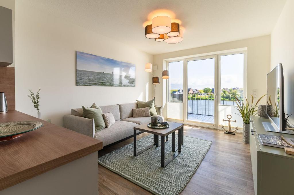 a living room with a couch and a table at Ferienwohnung Ankergold in Nordstrand