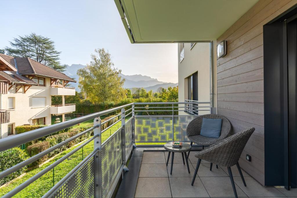 a balcony with two chairs and a table at Grand studio bord du lac in Saint-Jorioz