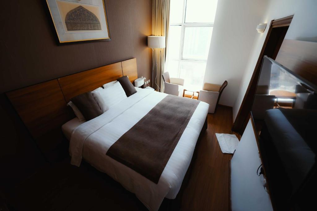 a bedroom with a bed and a window at Nour Al Thuria Hotel in Makkah