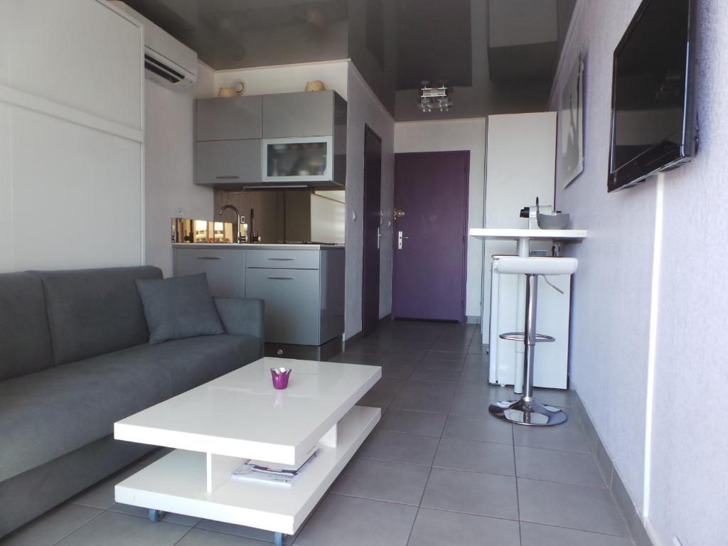 een woonkamer met een bank en een tafel bij le select in Cap d'Agde