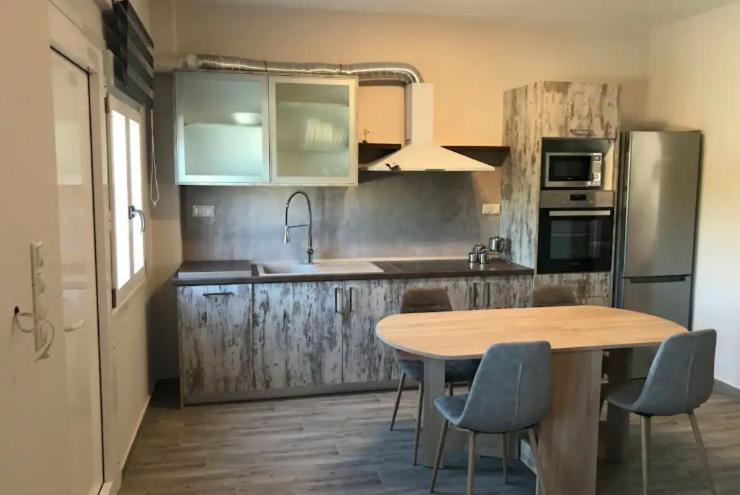 Pachia AmmosにあるCountry Houseのキッチン(木製のテーブルと椅子、テーブル付)、