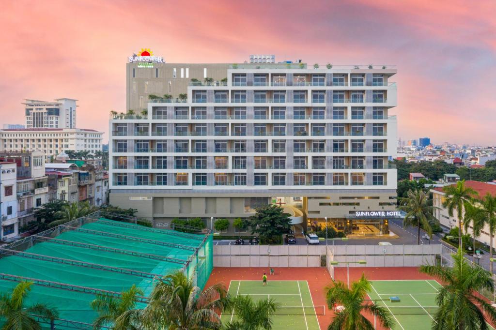 a hotel with a tennis court in front of it at Sunflower International Village in Hai Phong