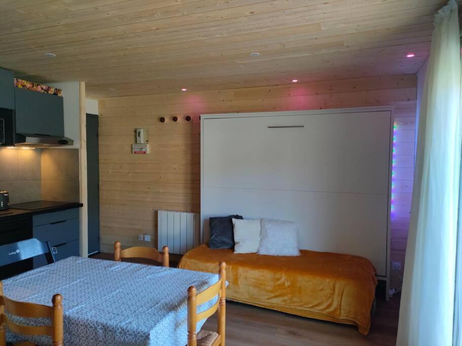 Appartement confort et style en pied de piste في بولكير بيرينيه 2000: غرفة نوم بسريرين وطاولة بيضاء على الحائط