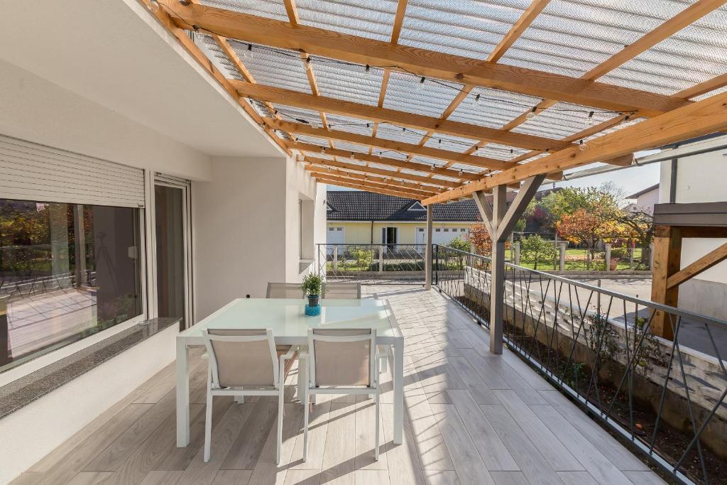 d'une terrasse avec une table et des chaises sous une pergola. dans l'établissement Apartments Rok, à Ljubljana