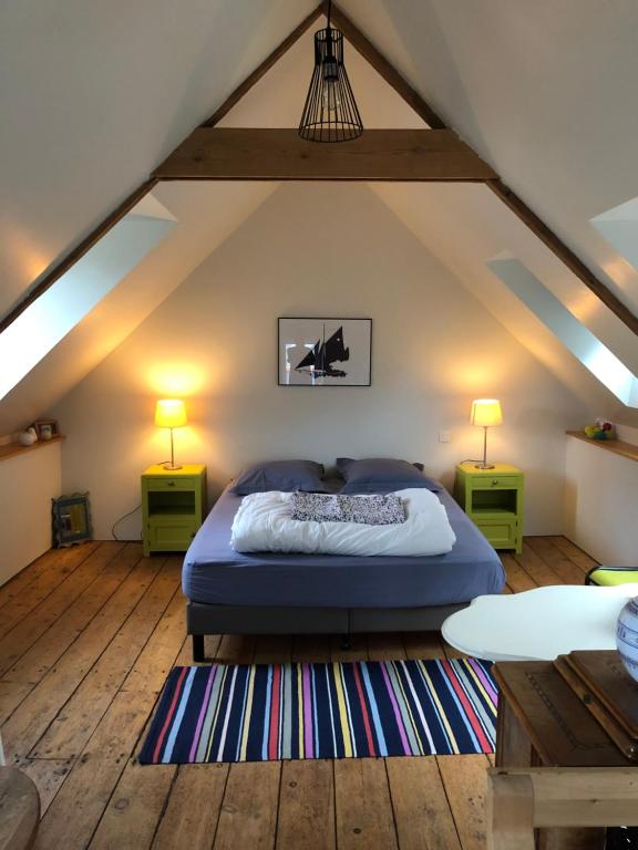 a bedroom with a bed and two lamps in a attic at La maison du pêcheur in Saint-Quay-Portrieux