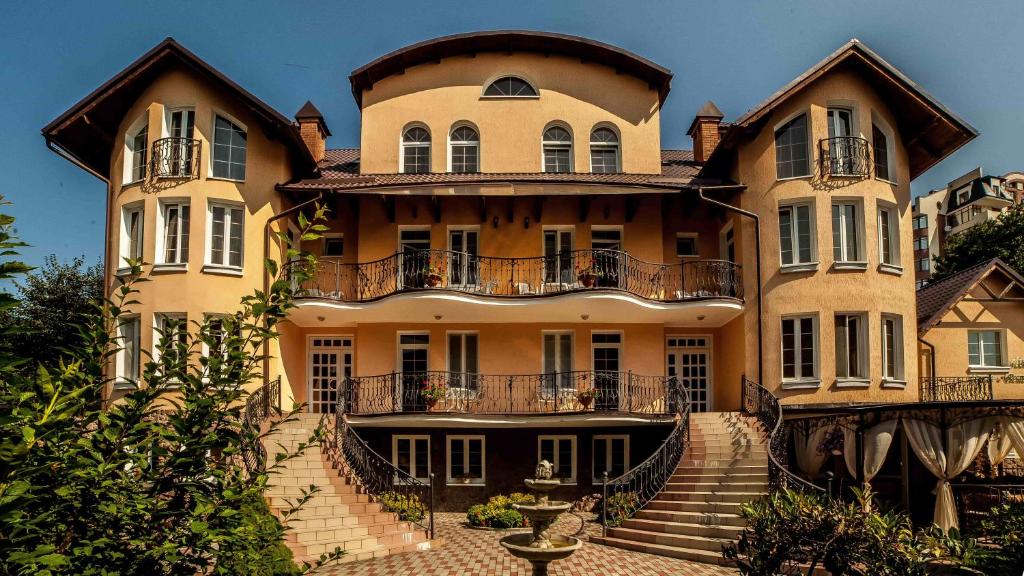 ein großes Gebäude mit einer Treppe davor in der Unterkunft Villa Marta in Truskawez