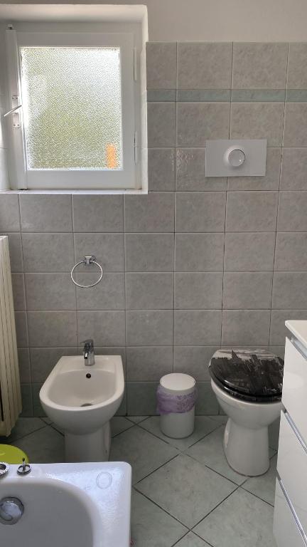 łazienka z umywalką, toaletą i oknem w obiekcie Bonsai - Bed & Breakfast w mieście Pesaro