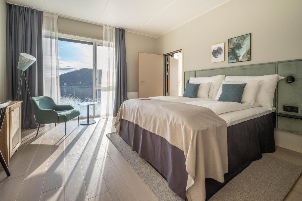 a bedroom with a large bed and a large window at Clarion Collection Hotel Arcticus in Harstad