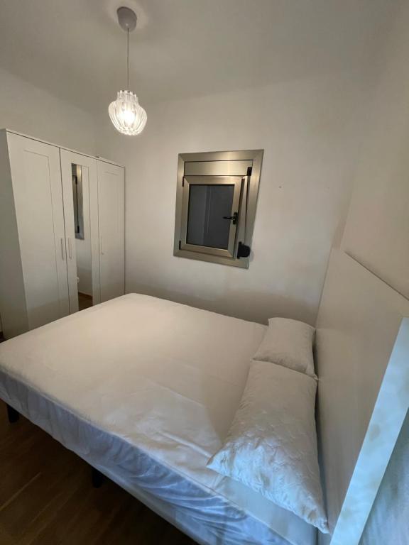 1 dormitorio con 1 cama y TV en la pared en Habitación acogedora en BCN en Esplugues de Llobregat