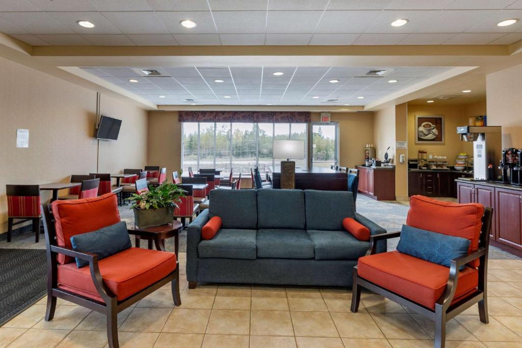 a waiting room with a couch and two chairs at Comfort Inn in Sturgeon Falls