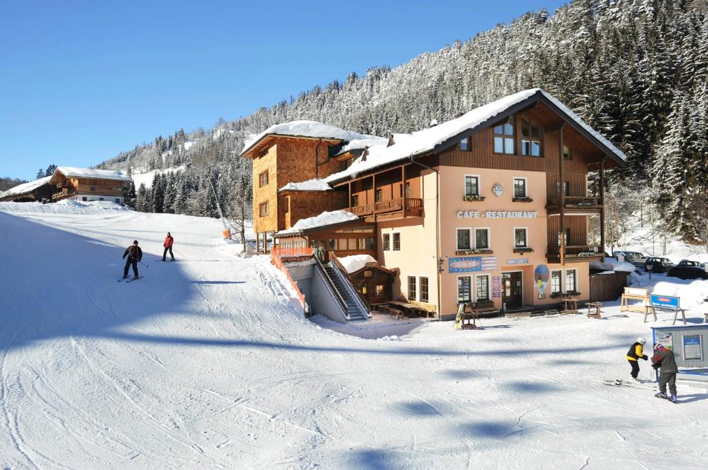 a group of people skiing in front of a ski lodge at Familienhotel Unterreith in Forstau