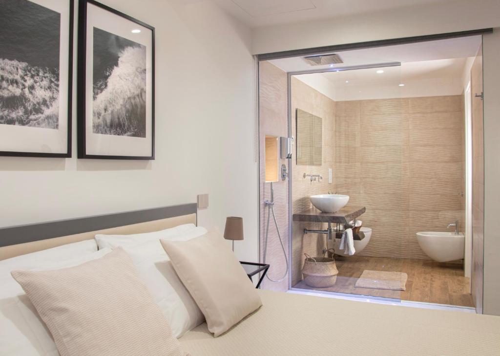 sypialnia z łóżkiem oraz łazienka z umywalką w obiekcie Luxury House Dogana 37 w mieście Salerno