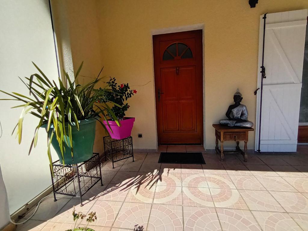 Zimmer mit einer Tür, Pflanzen und einem Tisch in der Unterkunft Chambres d'hôtes au pied des Pyrénées 