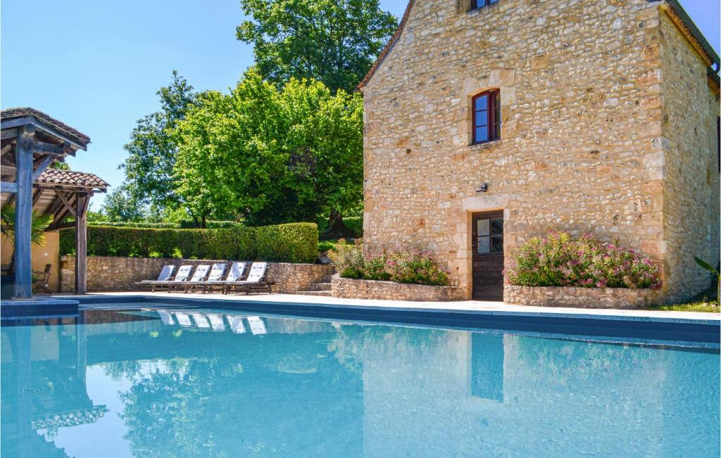 a swimming pool in front of a brick building at Beautiful Home In Fleurac With 3 Bedrooms, Private Swimming Pool And Outdoor Swimming Pool in Fleurac