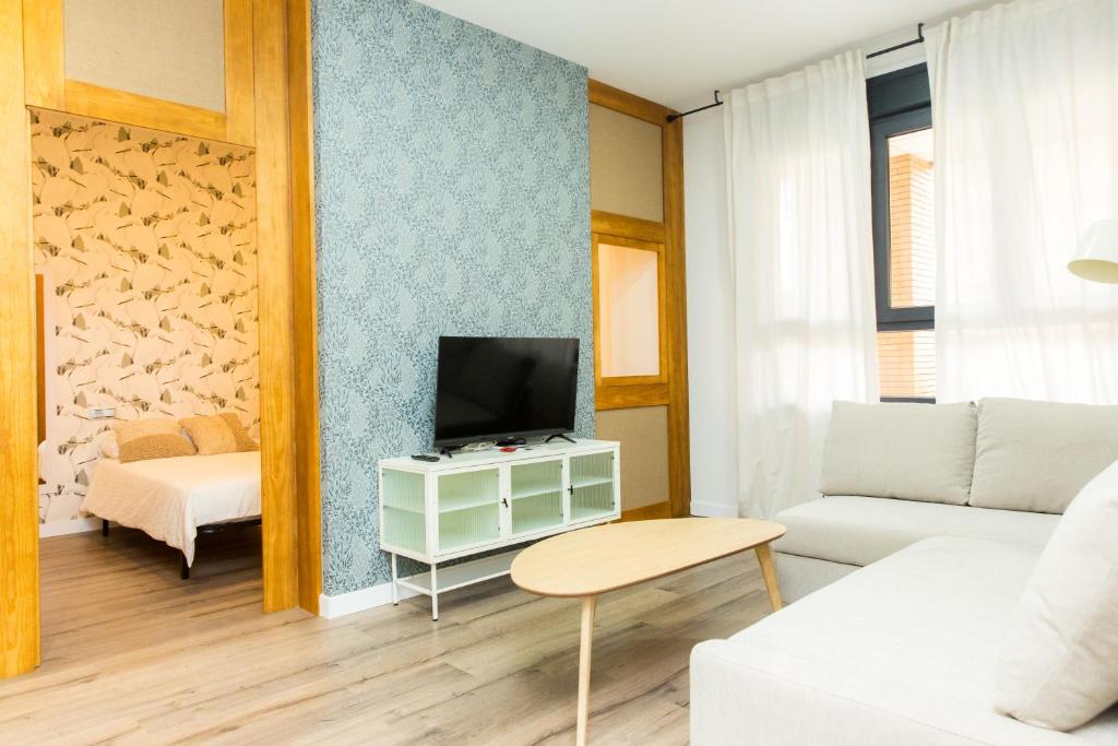 sala de estar con sofá y TV en Moderno Apartamento LAUD3 - Nuevo/Familiar/Wifi/TV, en Valladolid