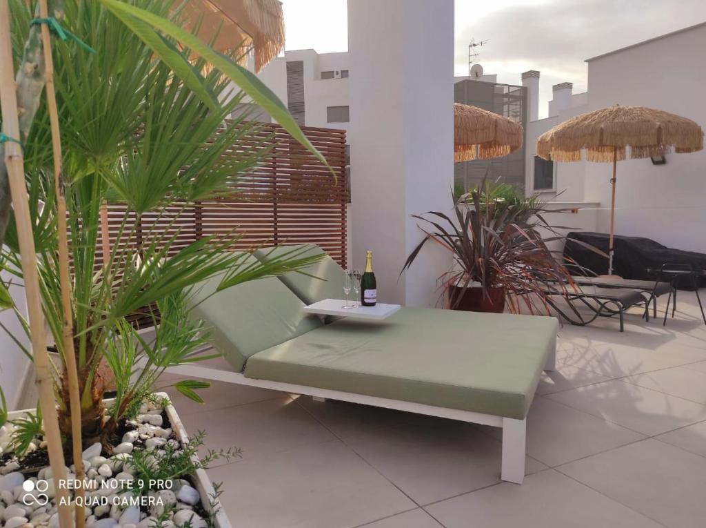 a green bench sitting in a room with plants at Appartement Baviera Hills - Torre del Mar - Costa del Sol in Caleta De Velez