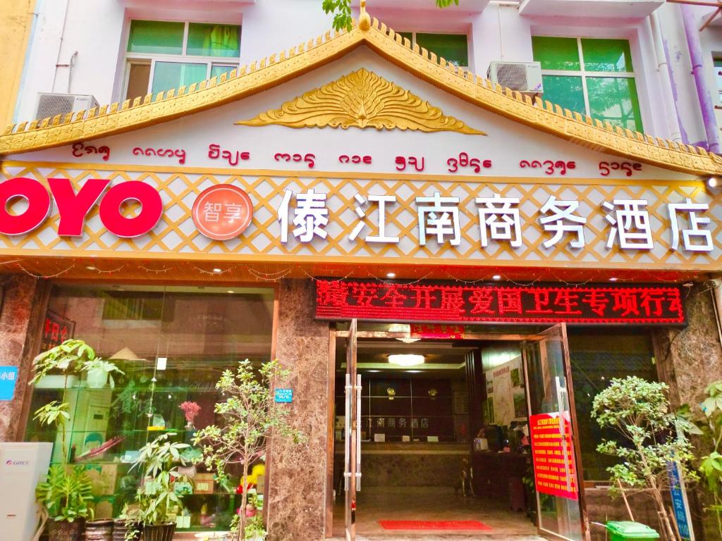 景洪市XiShuangBanNa International Aerial Garden South of Mekong River Business Hotel 傣江南商务酒店的大楼前有标志的餐厅