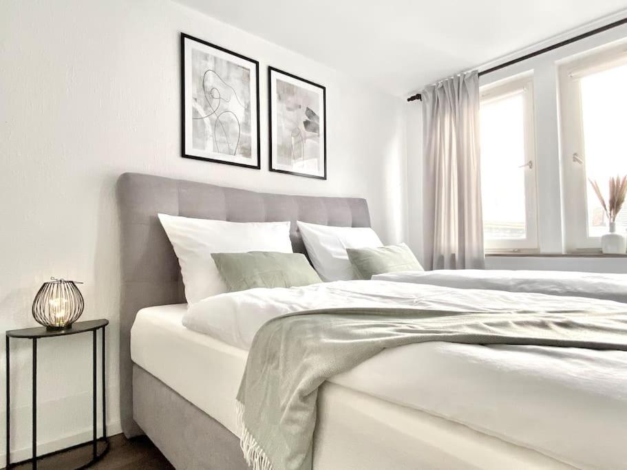 a white bedroom with a large bed and a window at City-Apartment No 2 in Reutlingen