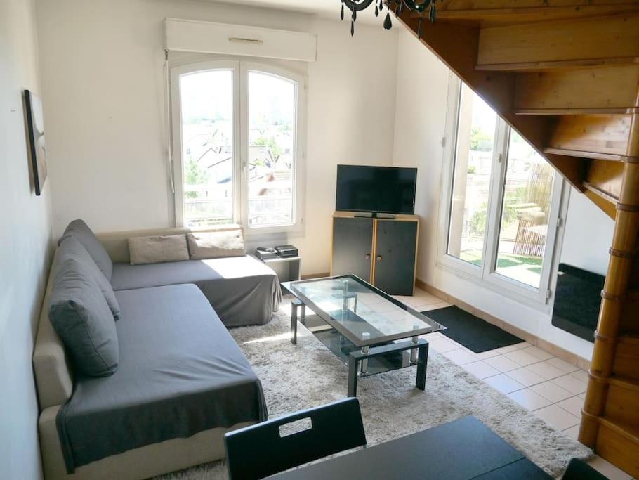 a living room with a couch and a table at Bobigny : 2 pièces proche a86 et commerces in Bobigny