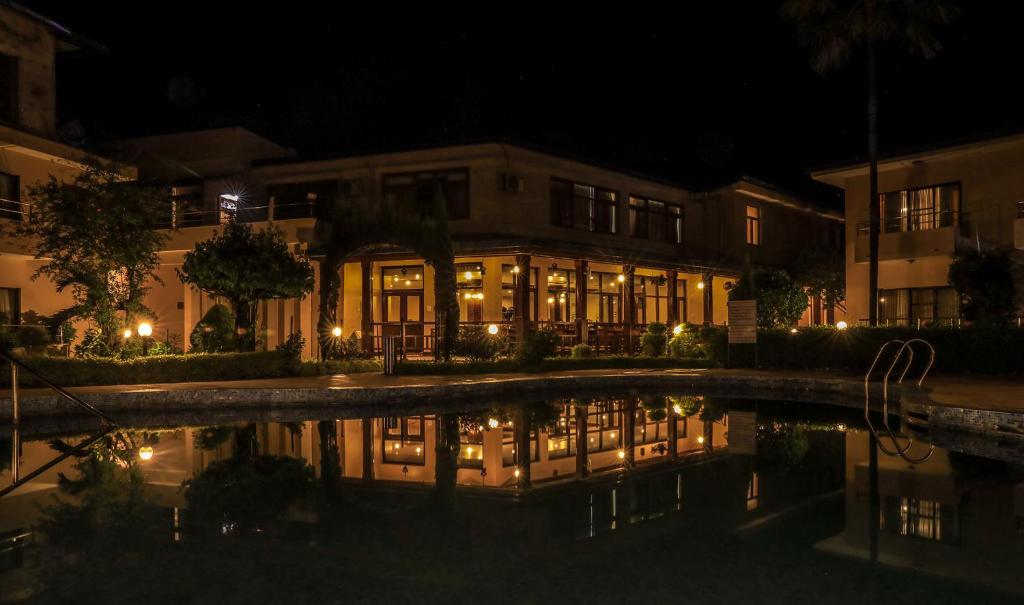 a building at night with a reflection in the water at Bharatpur Garden Resort in Bharatpur