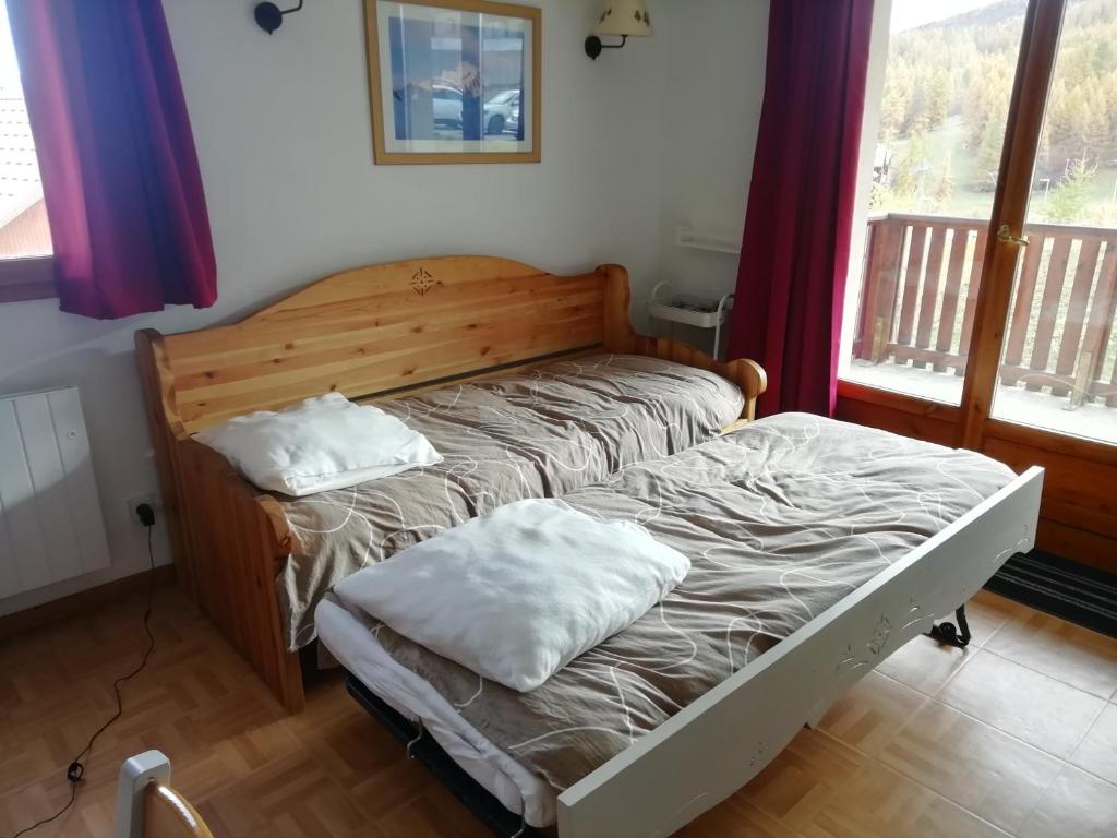 uma cama com duas almofadas num quarto em Espace et confort dans station familiale à 1800 m em Puy-Saint-Vincent