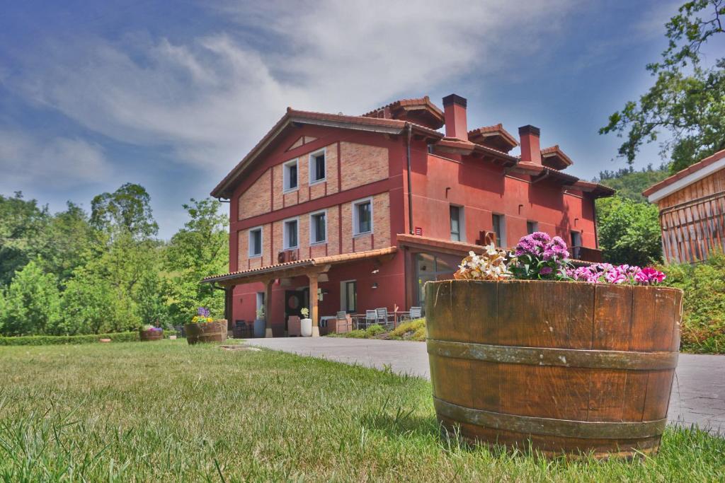 a large red house with a barrel in front of it at Hotel Rural Sagarlore in Astigarraga