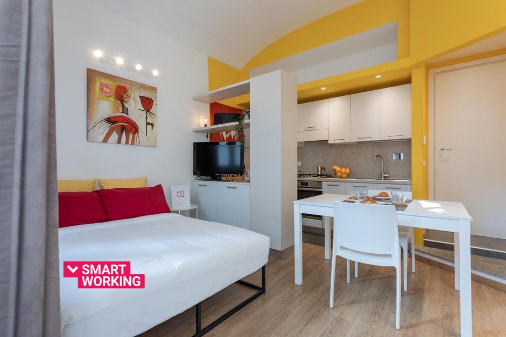 ein Schlafzimmer mit einem Bett und einem Tisch sowie eine Küche in der Unterkunft Porta Susa Studio Apartment by Wonderful Italy in Turin