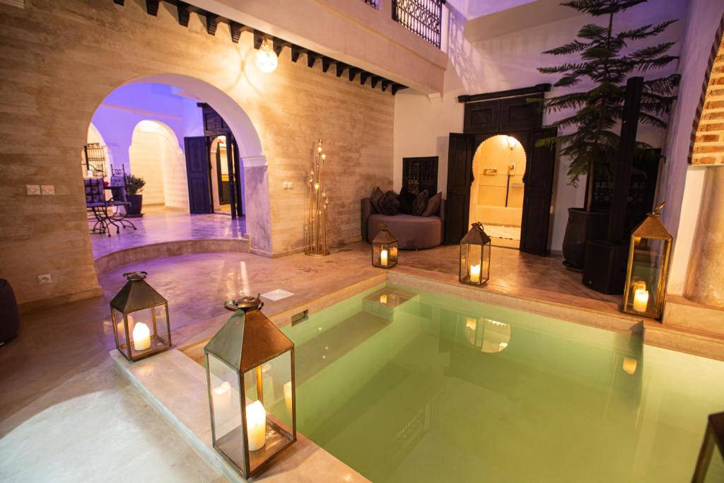 a swimming pool in a house with candles in it at Riad RIM in Marrakech