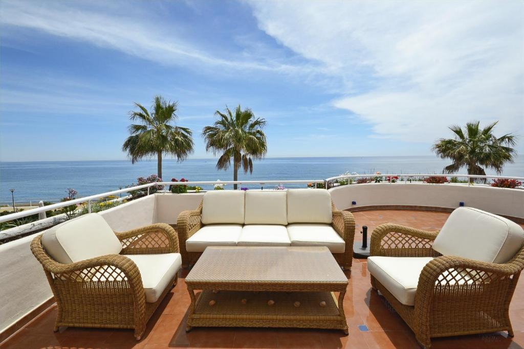 een patio met stoelen en een tafel en de oceaan bij Stunning unobstructed 180 degree sea view apartment with 100 square meters terrace - Costa del Sol - Estepona in Estepona
