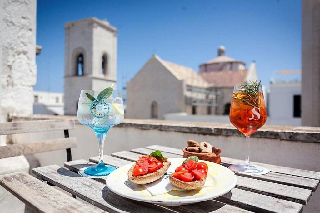 a table with a plate of food and two glasses at Dei Serafini in Polignano a Mare