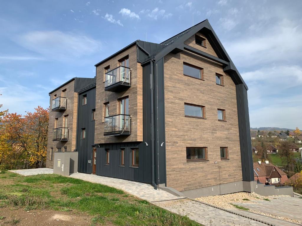 a large brick building with a black roof at Apartmán v Krkonoších - Černý Důl in Černý Dŭl