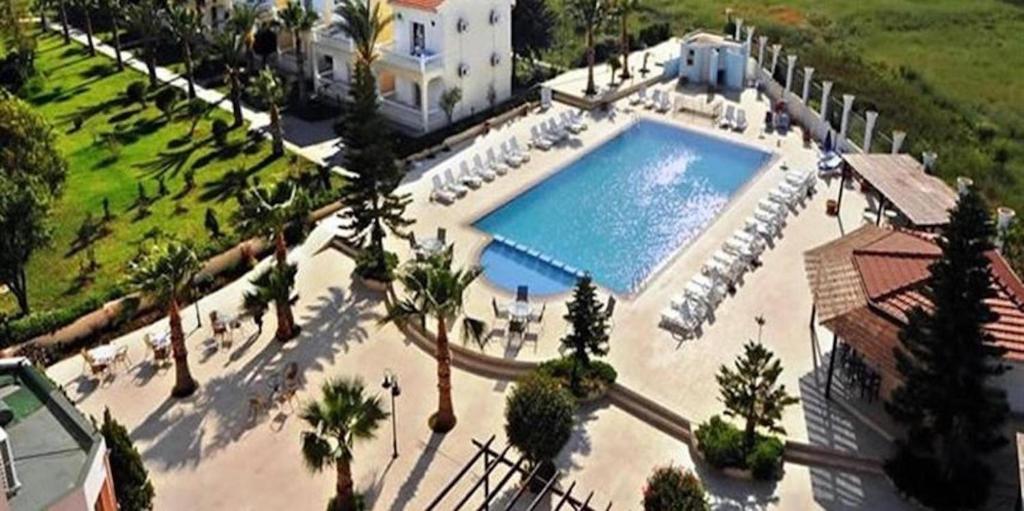 una vista aérea de una gran piscina con sillas y palmeras en Mountain View Hotel en Kyrenia