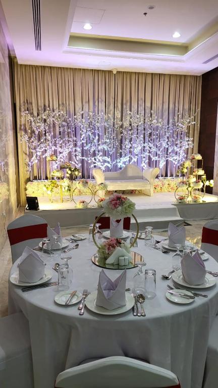 a white table with plates and silverware on it at Red Castle Hotel in Sharjah