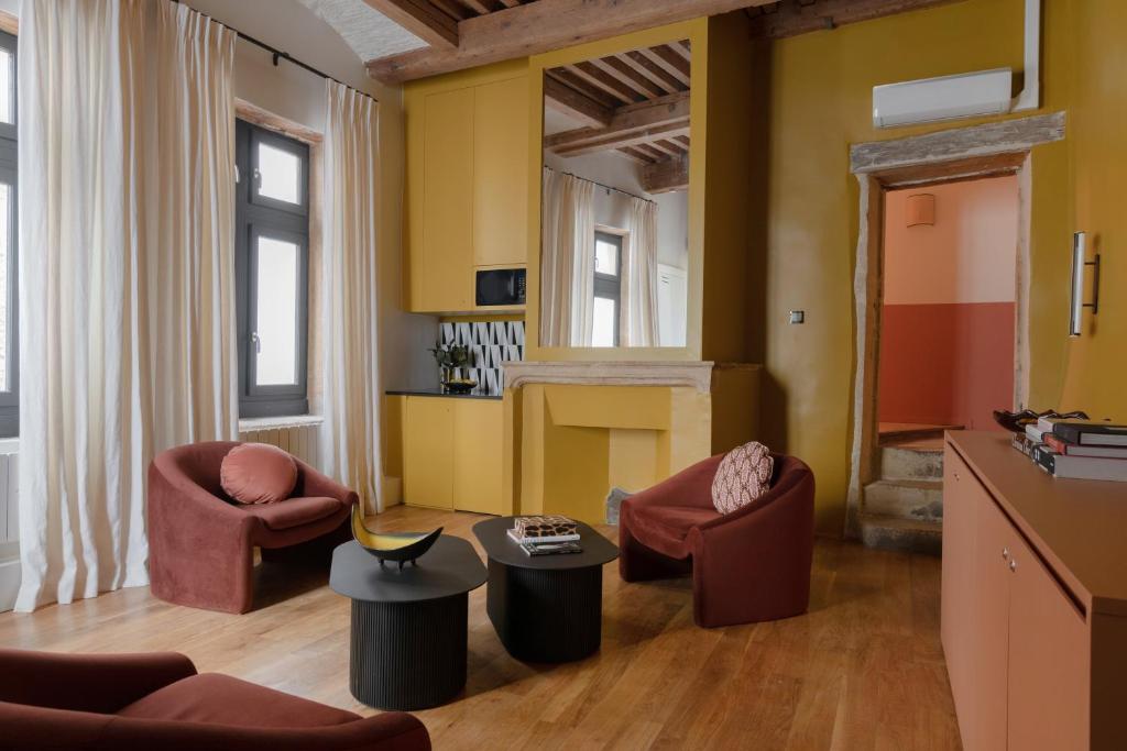 a living room with two chairs and a fireplace at MiHotel Saint Jean in Lyon