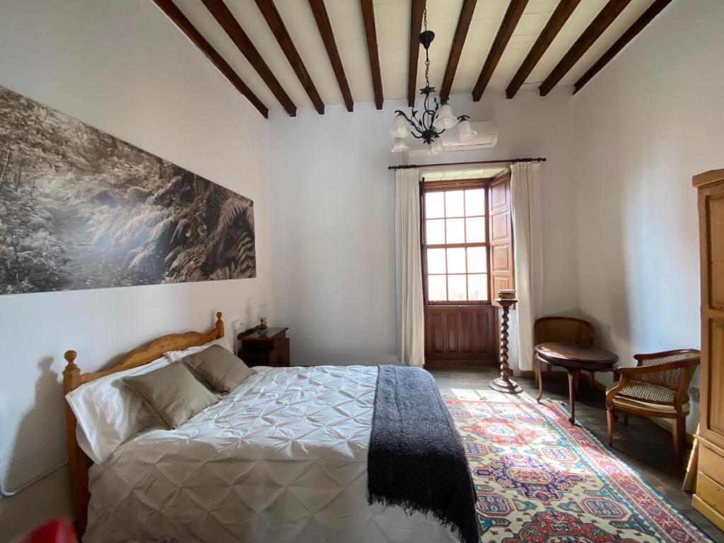 a bedroom with a bed and a large painting on the wall at NEW ELEGANCE TRADITIONAL CANARIAN HOME CASA MÁ , Tenerife South in Arona