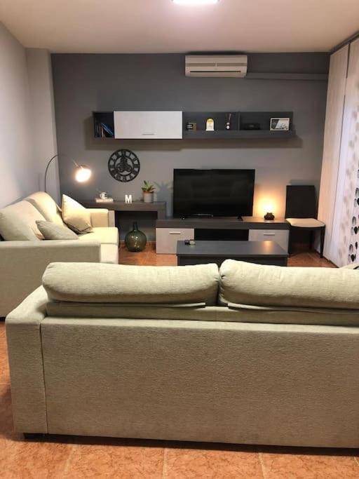 a living room with a couch and a flat screen tv at CHEZ GREDOS in Candeleda