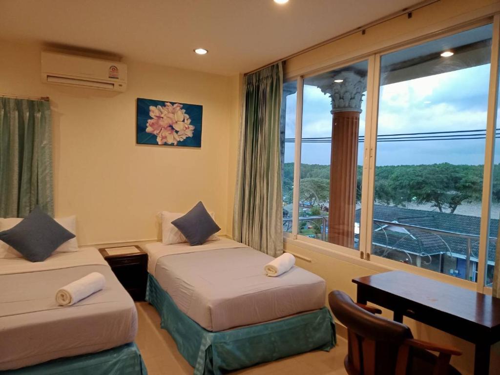 a hotel room with two beds and a window at Marina Seaview Krabi in Krabi town