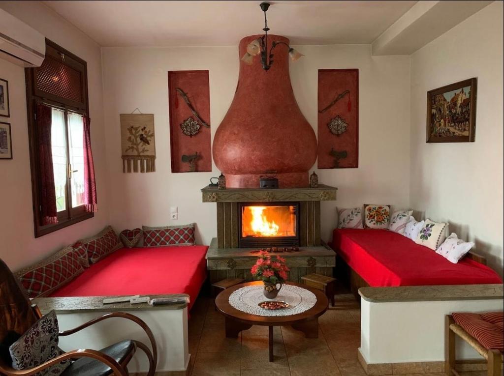a living room with two beds and a fireplace at Η θεα traditional house in Makrinítsa