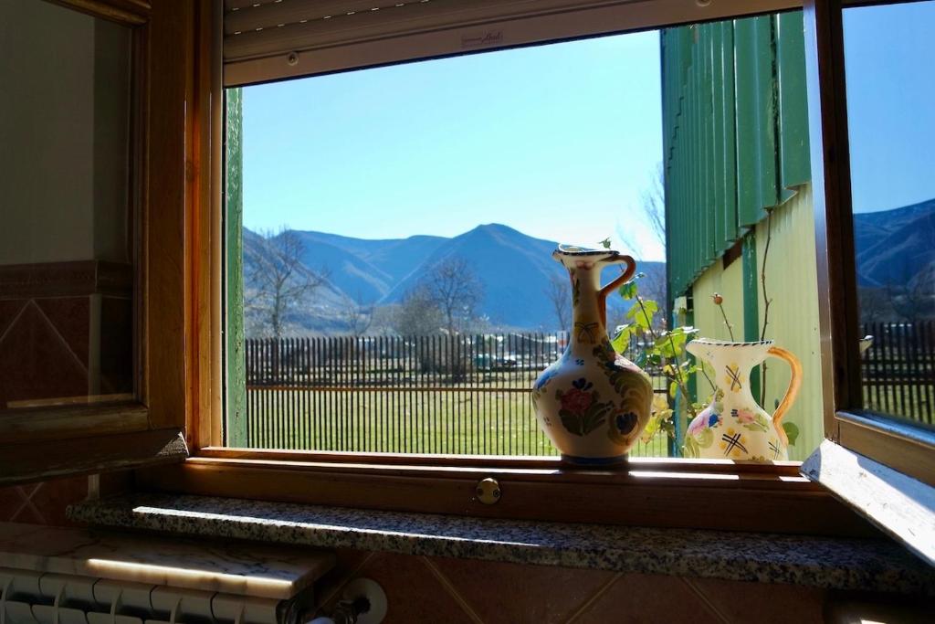 una ventana con dos jarrones sentados en un alféizar de la ventana en La Furmumecha VUT-LE-611 Apartamento, en Villablino